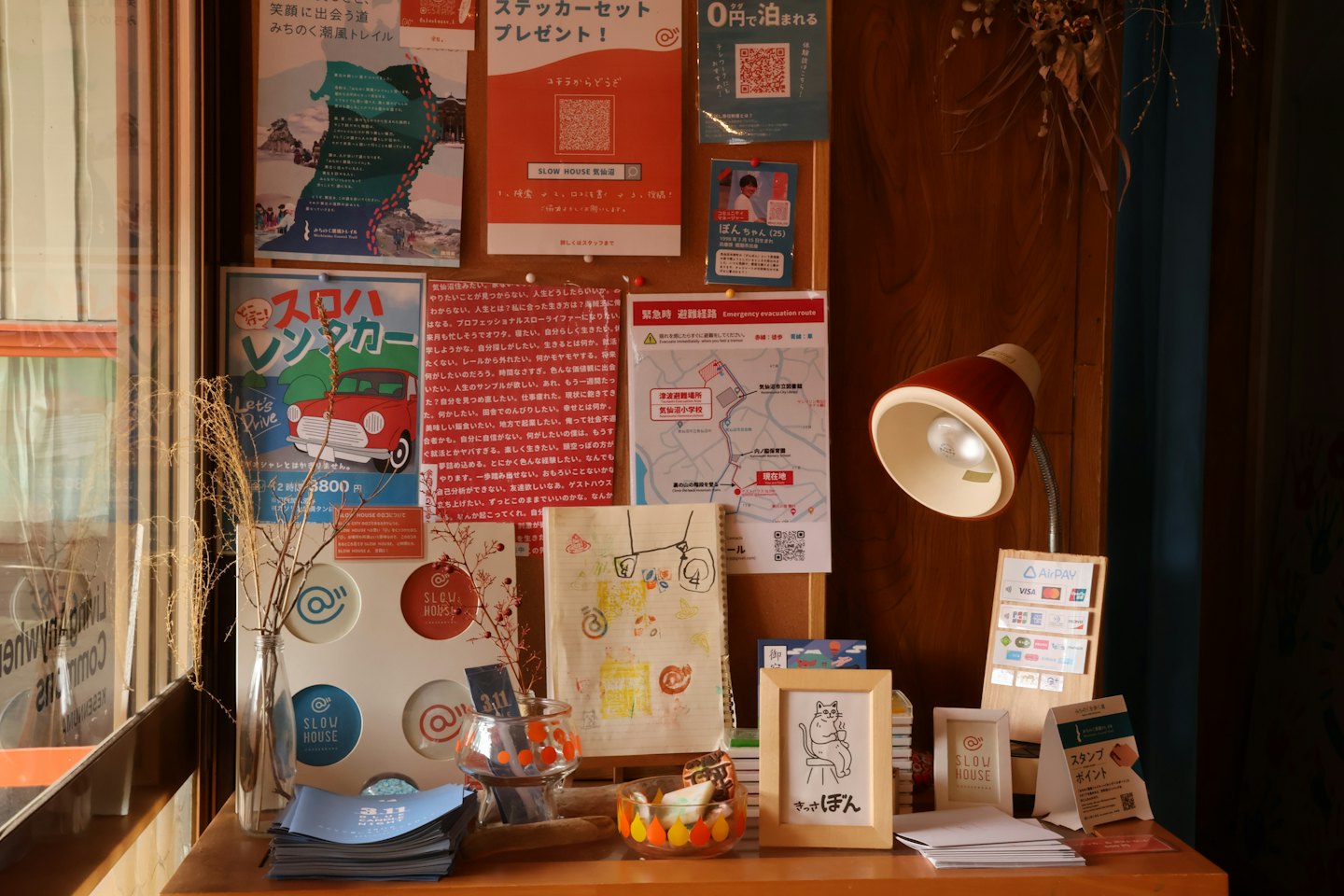 Bureau en bois et tableau d'affichage recouverts de matériel promotionnel japonais.